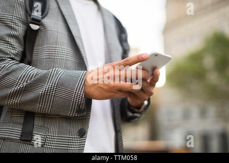 Midsection of businessman using smart phone Stock Photo