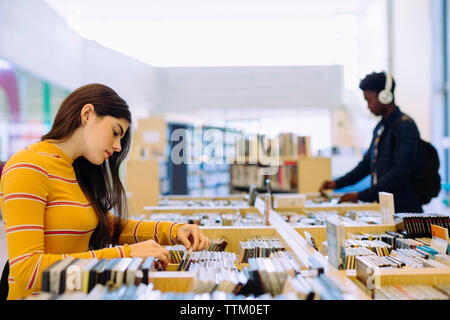 Side view of students choosing books in library Stock Photo