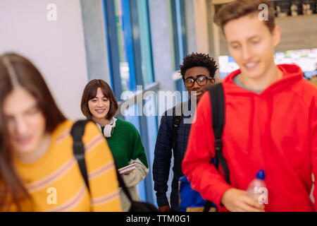High angle view of friends walking in corridor at library Stock Photo