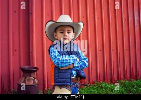 Portrait of confident boy wearing cowboy hat Stock Photo