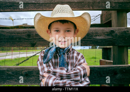 Portrait of happy boy wearing cowboy hat on field Stock Photo