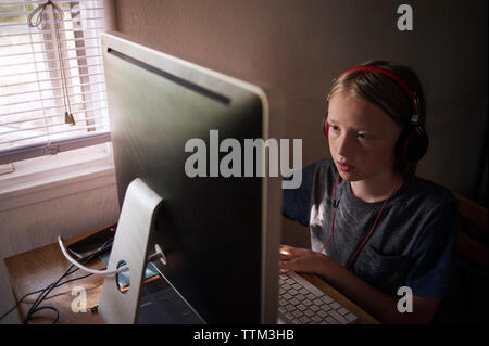 Boy using computer at desk Stock Photo