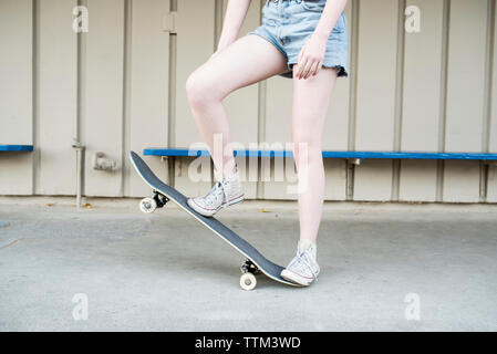 Low section of teenage girl skateboarding at park Stock Photo
