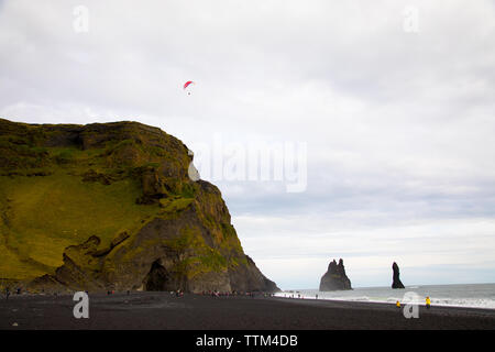 Paraglider over Reynisfjara Beach Iceland with tourists Stock Photo