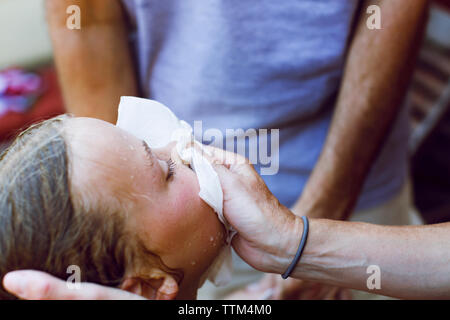 Cropped image of man covering girl's bleeding nose Stock Photo