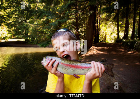 Boy pretending to bite fish Stock Photo