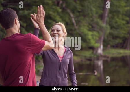 Friends high fiving eachother during hike through forest in eastern Canada Stock Photo