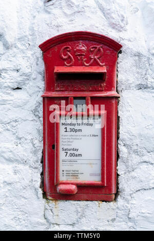 Detail of traditional old red postbox on white wall Stock Photo