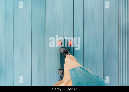 High angle view of man skateboarding on wooden floorboard in city Stock Photo