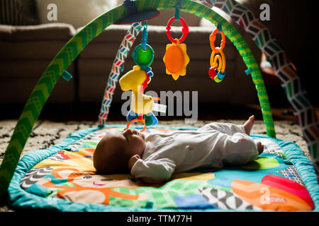 Baby girl lying on playmat at home Stock Photo