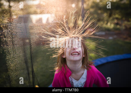 High angle view of cheerful girl jumping on trampoline in backyard Stock Photo