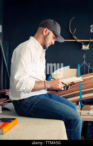 Craftsperson taking notes Stock Photo