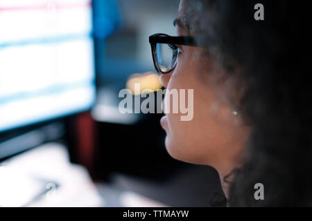 Close-up of businesswoman wearing eyeglasses while looking at computer in office Stock Photo