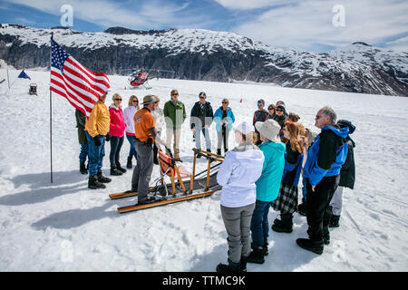 USA, Alaska, Juneau, the groups huddles together prior to going dog sledding, Helicopter Dogsled Tour flies you over the Taku Glacier to the HeliMush Stock Photo