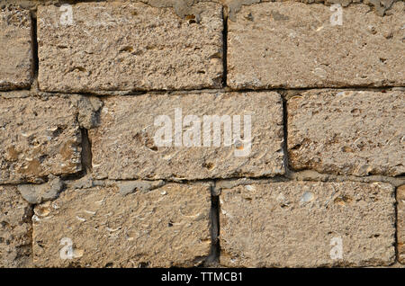 Stone bricks from limestone laid by a wall and fastened by cement. Background. Stock Photo