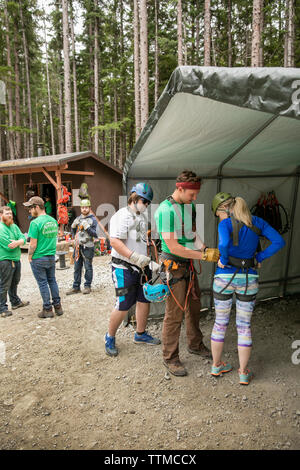 USA Alaska, Sitka, participants prepare for their 4-hour adventure where they will zip past massive spruce, cedars and glacially fed waterfalls, Grizz Stock Photo