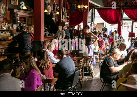 USA, Alaska, Sitka, guests take a break from walking around the streets of downtown Sitka to eat lunch at the Red Onion Saloon Stock Photo