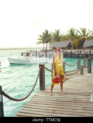 ARUBA, portrait of young woman standing on a dock with her snorkel gear, Renaissance Island Stock Photo