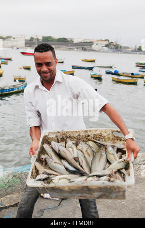 BRAZIL, Rio de Janiero, a Fishermen brings in a tub of fresh caught fish, Harbor Praca XV Stock Photo