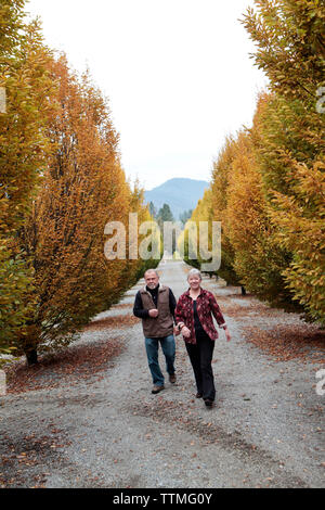 USA, Oregon, Medford, Cal and Judy Schmidt stand among the trees on their farm, Schmidt Family Vineyards is located in the beautiful Applegate Valley Stock Photo