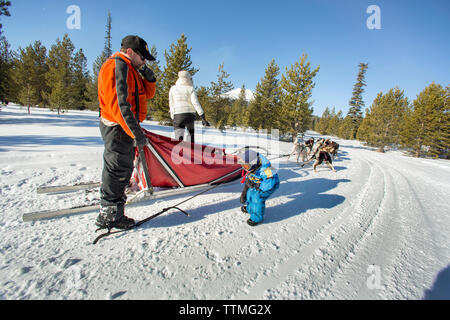 USA, Oregon, Bend, the musher showing a young boy the different parts of the dog sled