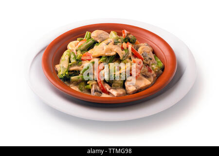 Stewed meat with vegetables and mushrooms in sour cream sauce, isolated on white background Stock Photo