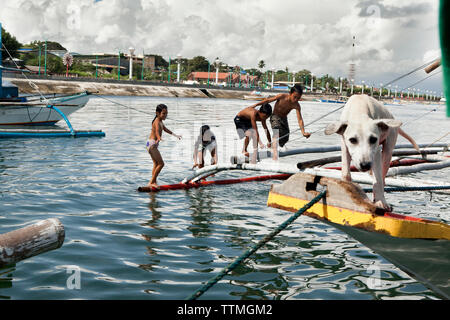 PHILIPPINES, Palawan, Puerto Princesa, kids play on fishing boats in the City Port Area Stock Photo