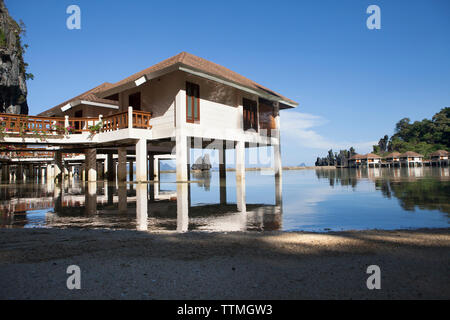 PHILIPPINES, Palawan, El Nido, Lagen Island Resort cottages sit over the water and below the rocky cliffs in Bacuit Bay in the South China Sea Stock Photo