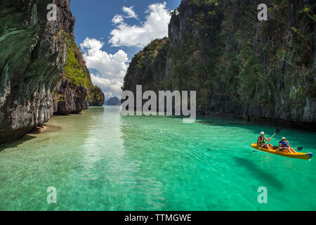 PHILIPPINES, Palawan, El Nido, Miniloc Island, tourists kayak through the crystal clear waters of Big Lagoon on Miniloc Island located in Bacuit Bay i Stock Photo