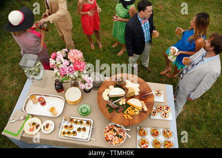 USA, Tennessee, Nashville, Iroquois Steeplechase, friends stand around a buffet table eating and drinking Stock Photo