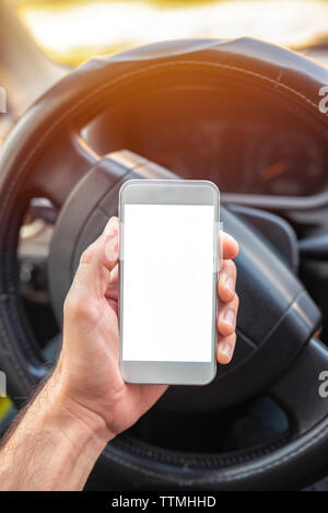 Using smartphone in car, mock up blank screen of mobile phone device in hand of adult caucasian male Stock Photo