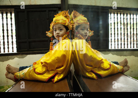 VIETNAM, Hue, Tu Duc Tomb, a young dancer is dressed in traditional Vietnamese costume and waits to perform with his mother Stock Photo