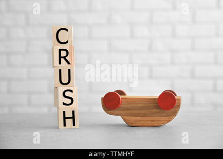 Cubes with word CRASH and toy car on brick wall background Stock Photo