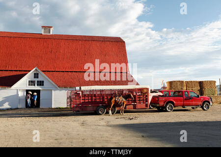 USA, Wyoming, Encampment, a cowboy and cowgirl stand in the doorway of a barn, Big Creek Ranch Stock Photo