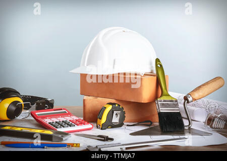 Construction blueprints with tools and helmet on light background Stock Photo