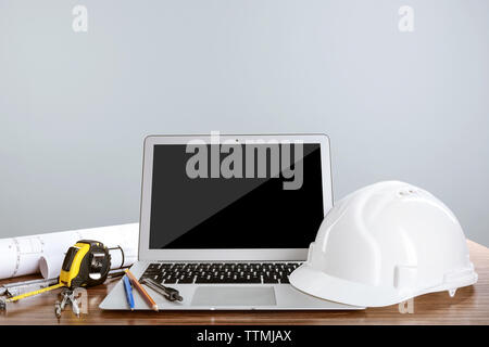 Laptop with construction tools on wooden table Stock Photo