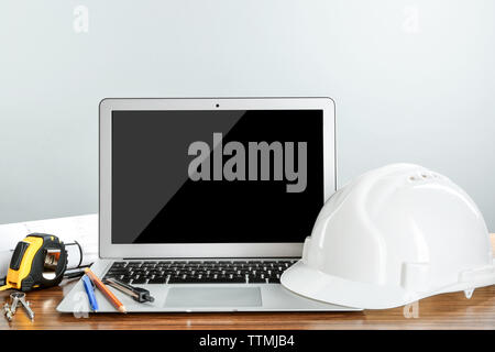 Laptop with construction tools on wooden table Stock Photo