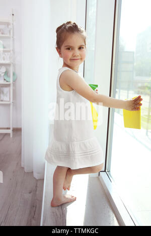 Cute little girl cleaning window Stock Photo