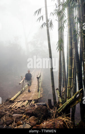 INDONESIA, Flores, Bernd Schwer stands for a portrait on a bamboo walking bridge on the way to Wae Rebo Village Stock Photo