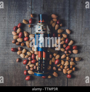 Overhead view of wooden nutcracker figurine and dried food on table Stock Photo