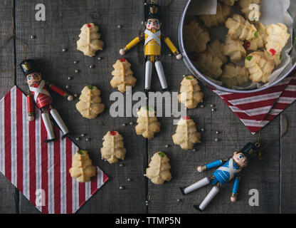 Overhead view of figurines with cookies on wooden table during Christmas Stock Photo