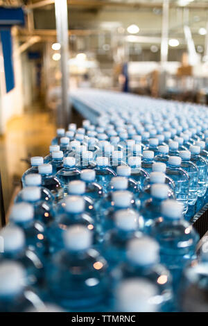 Close-up of water bottles on conveyor belt in industry Stock Photo