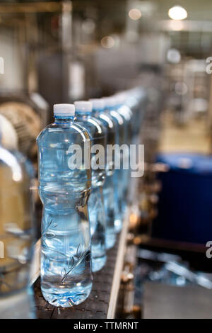 Close-up of water bottles in row at factory Stock Photo