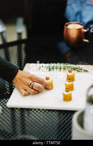 Cropped image of woman table appetizer served on white board in backyard Stock Photo
