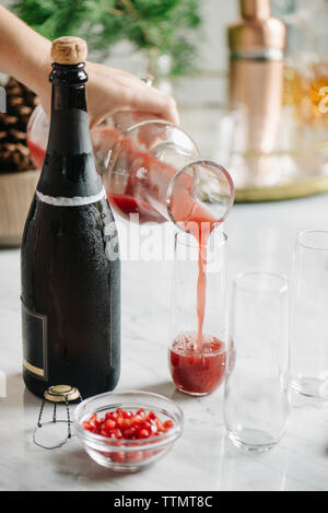 Cropped image of woman pouring juice in glass at home Stock Photo