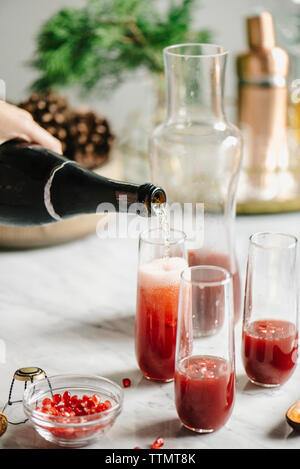 Cropped image of woman pouring champagne in juice Stock Photo