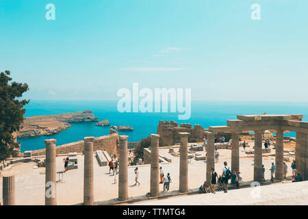 High angle view of tourists visiting archeological site against blue sky during sunny day Stock Photo