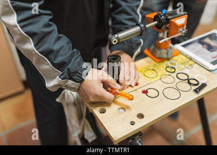 Midsection of mechanic using equipment at workshop Stock Photo