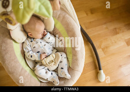 High angle view of baby boy sucking thumb while sleeping in bassinet at home Stock Photo