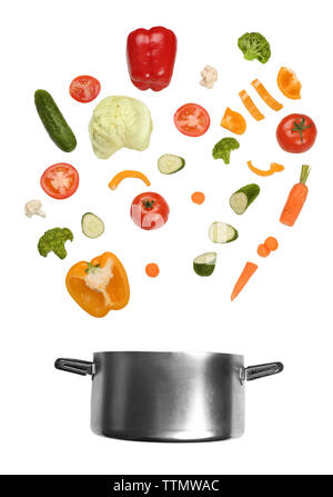 Different vegetables falling into saucepan on white background Stock Photo